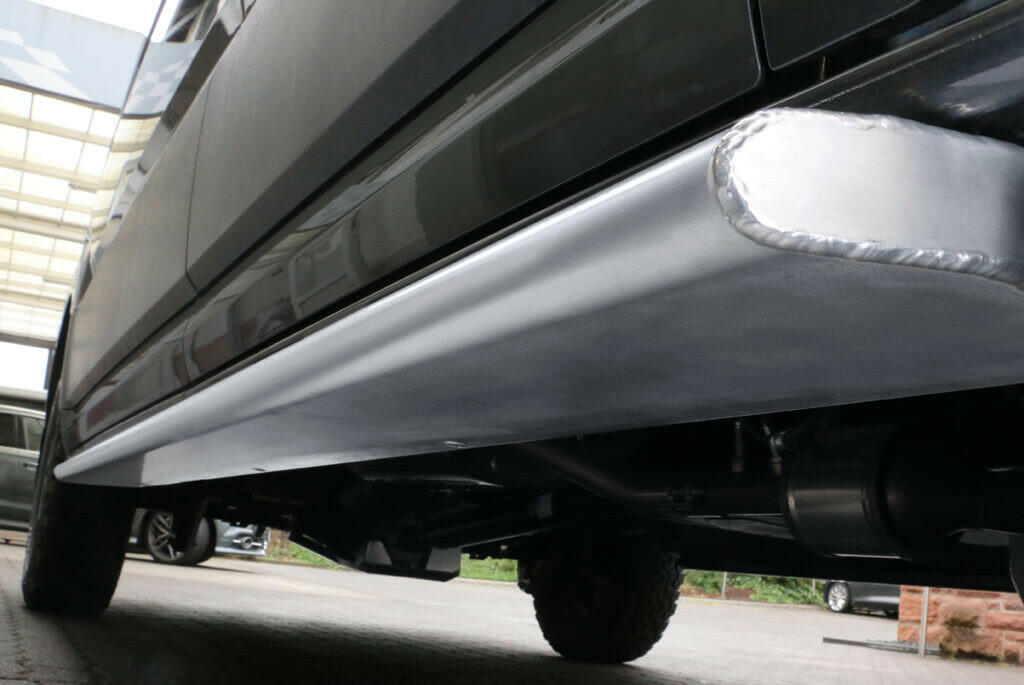 Side undercarriage view of a grey car showing the exhaust and bottom panels