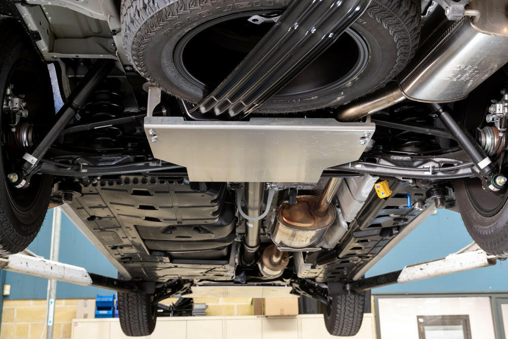 Undercarriage view of a vehicle showing suspension, exhaust system, and spare tire