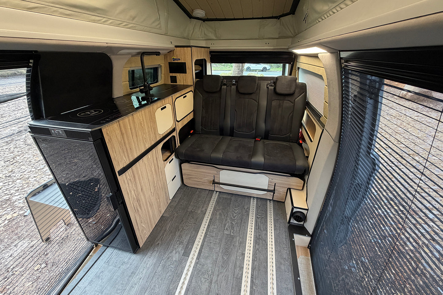 
                  
                    Trakkadu interior with rear bench seat, timber cabinets and kitchen unit
                  
                